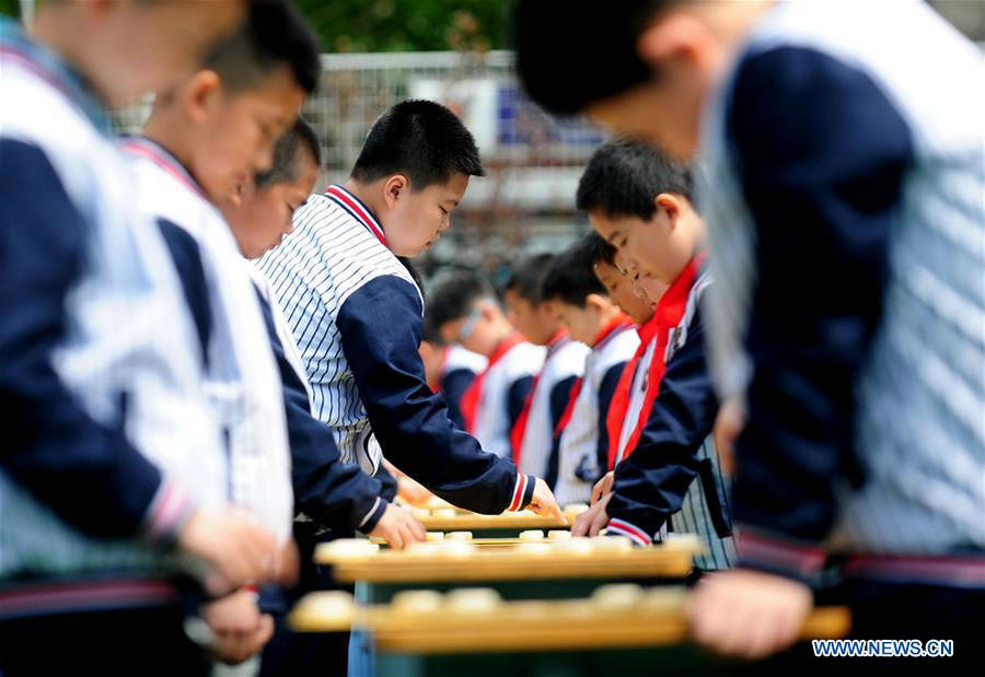 Pupils play Chinese chess during activity in NE China