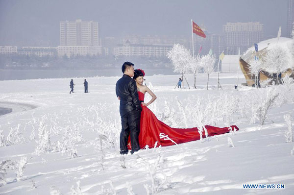 Newly-married couple enjoy rime along Songhua River in NE China