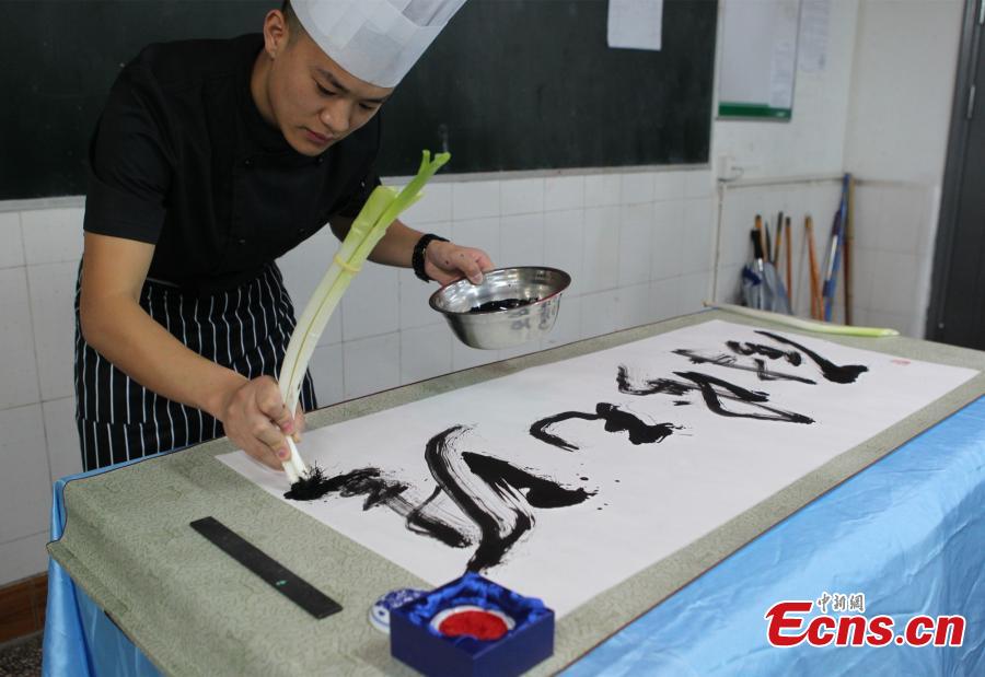 Man writes Chinese calligraphy using kitchenware