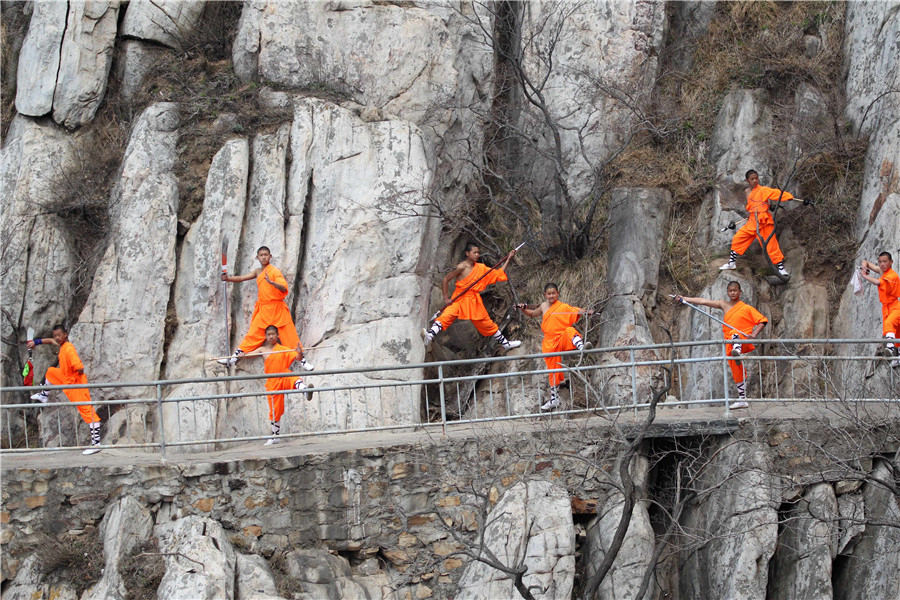 Martial artists practice Shaolin kung fu on cliff