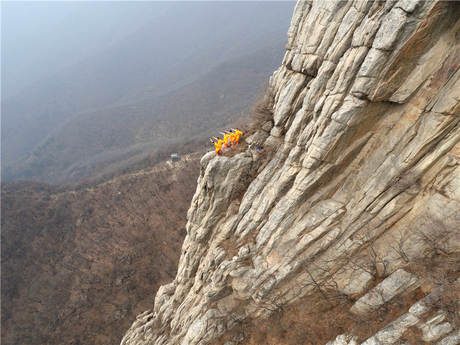 Martial artists practice Shaolin kung fu on cliff