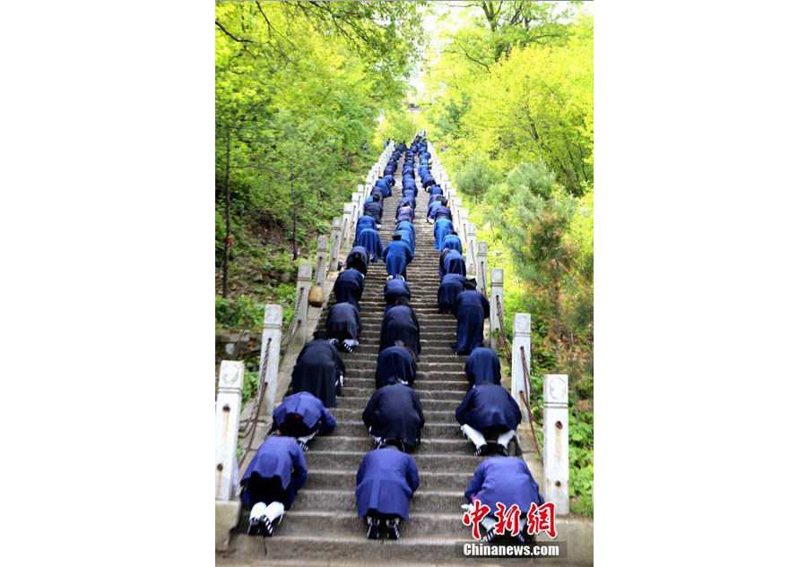 Taoist priests worship their ancestors by kneeling down on stone steps