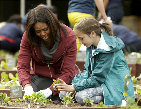 Michelle Obama plants vegetables with school children
