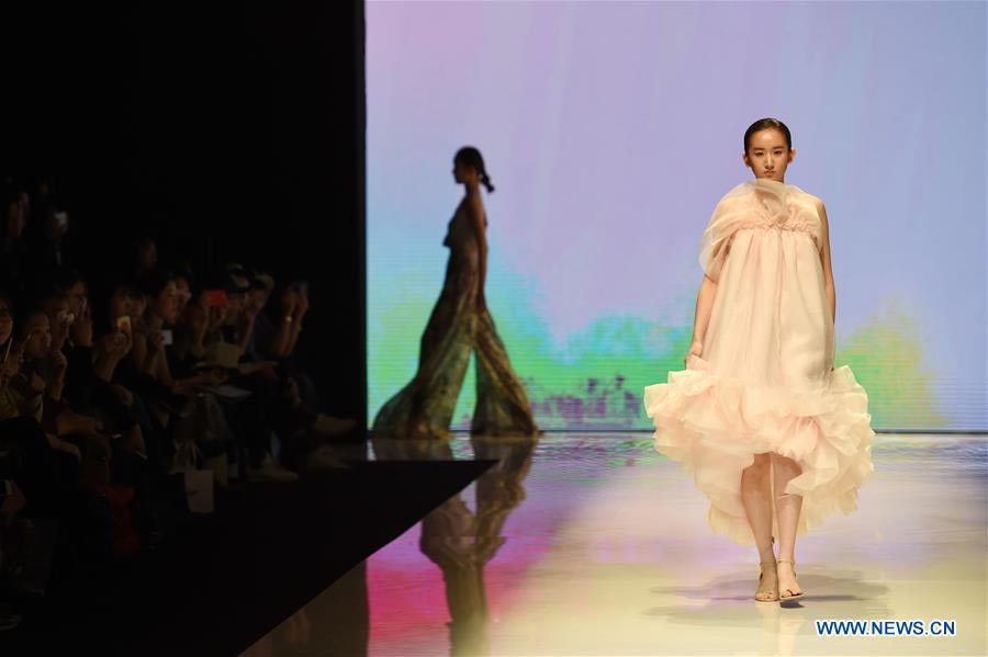 Models present fashion designs of graduates in Beijing