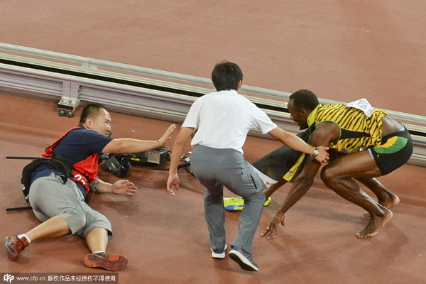 Bolt does backward somersault after cameraman knocks him down