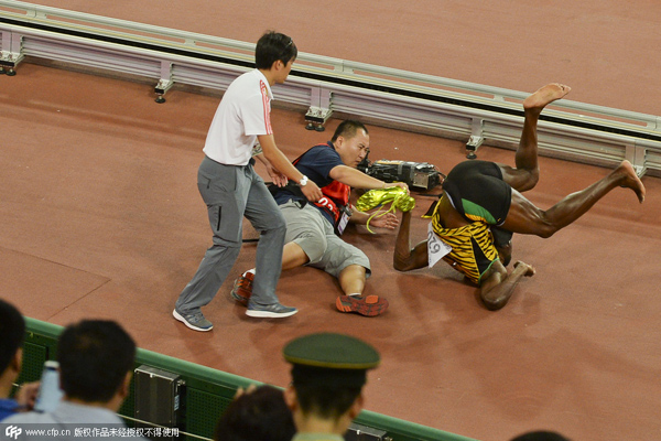 Bolt does backward somersault after cameraman knocks him down