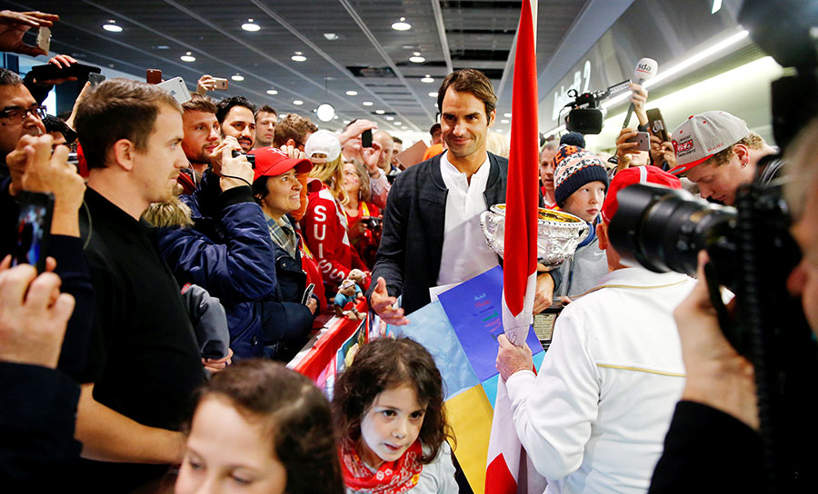 Trophy-holding Federer receives hero's welcome back home