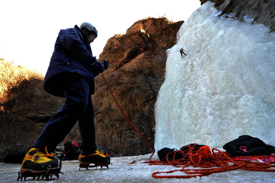 Tourists do ice climbing on frozen waterfall in suburb of Beijing